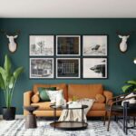 A dark green living room setup featuring a warm brown leather sofa, large indoor plants, and artistic wall decor at Kuda Putih Pandawa.