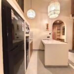 Detailed view of the suite amenities including a full-size refrigerator, microwave, and water dispenser in the kitchenette at Kuda Putih Pandawa guesthouse.