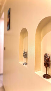 Close-up of traditional Balinese statues placed in illuminated wall niches, adding a touch of cultural elegance to the Deluxe Double room at Kuda Putih Pandawa.